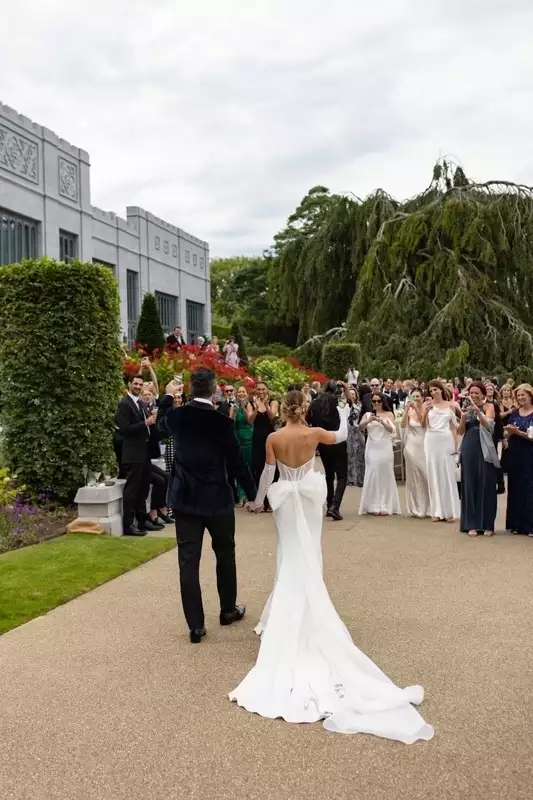 Olivia Amato arrives to drinks reception with her husband on wedding day