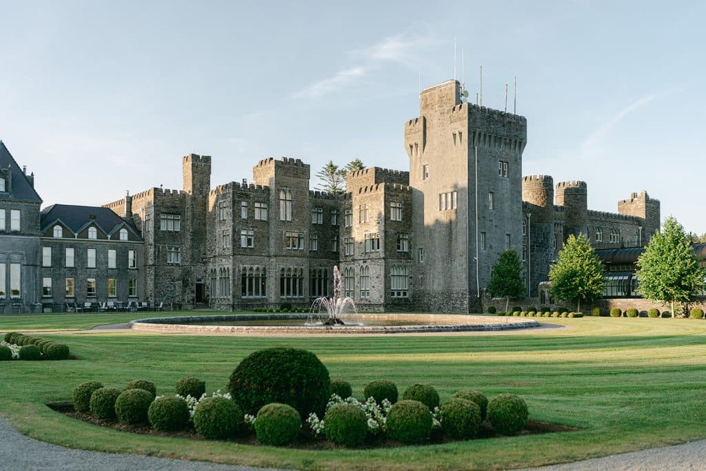 Aerial view of Ashford Castle from Lough Corrib, showcasing an iconic Irish castle wedding venue, part of a luxury destination wedding in Ireland planned by Olivia Buckley International