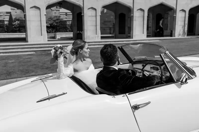 Destination wedding at Adare Manor, County Limerick — bride and groom seated in a vintage white convertible outside the manor following the wedding ceremony.