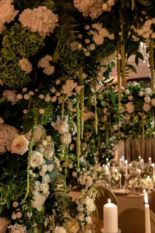 Destination wedding at Adare Manor, County Limerick — close-up detail of a white floral installation with greenery during the wedding dinner.