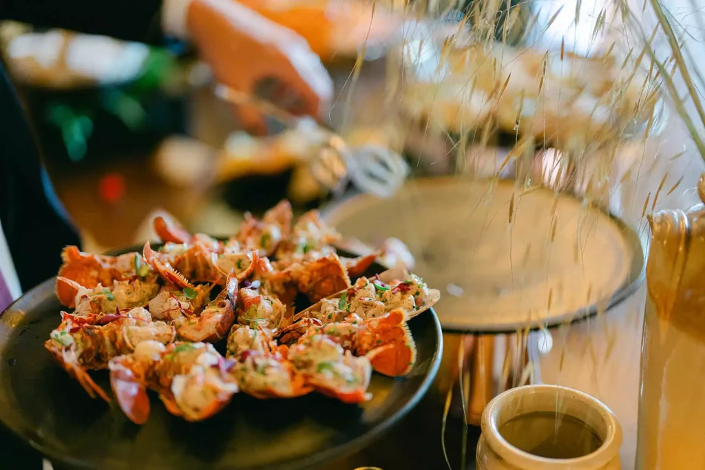 Plate of stuffed lobster tails garnished with herbs on a buffet table