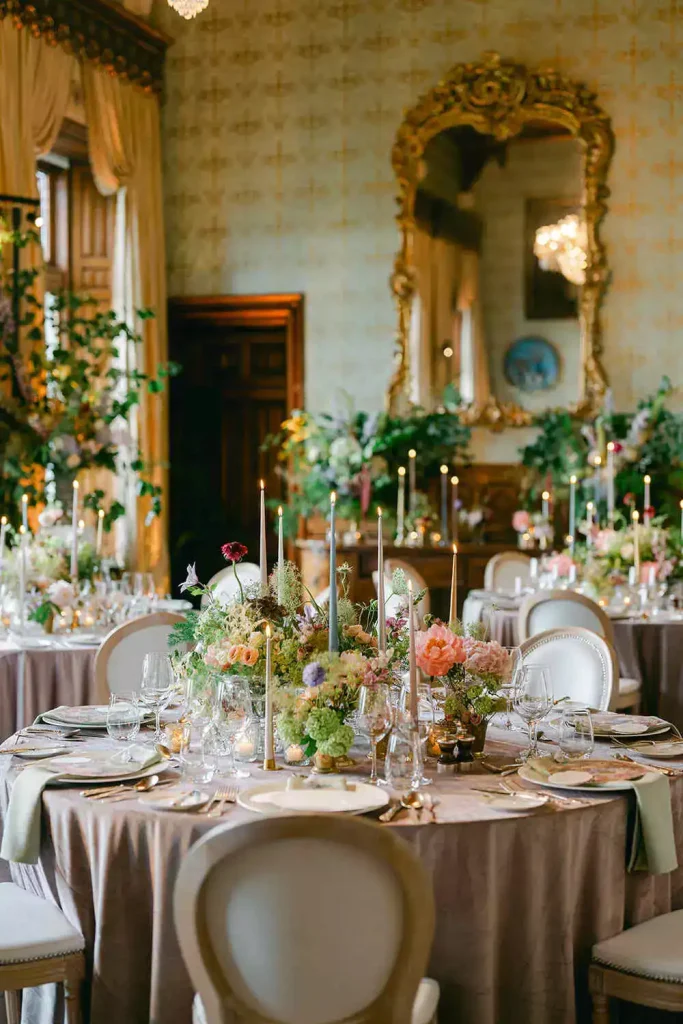 Destination wedding in Ireland at Ashford Castle, County Mayo — reception dining table with floral centrepieces and candlelight arranged for the wedding dinner.