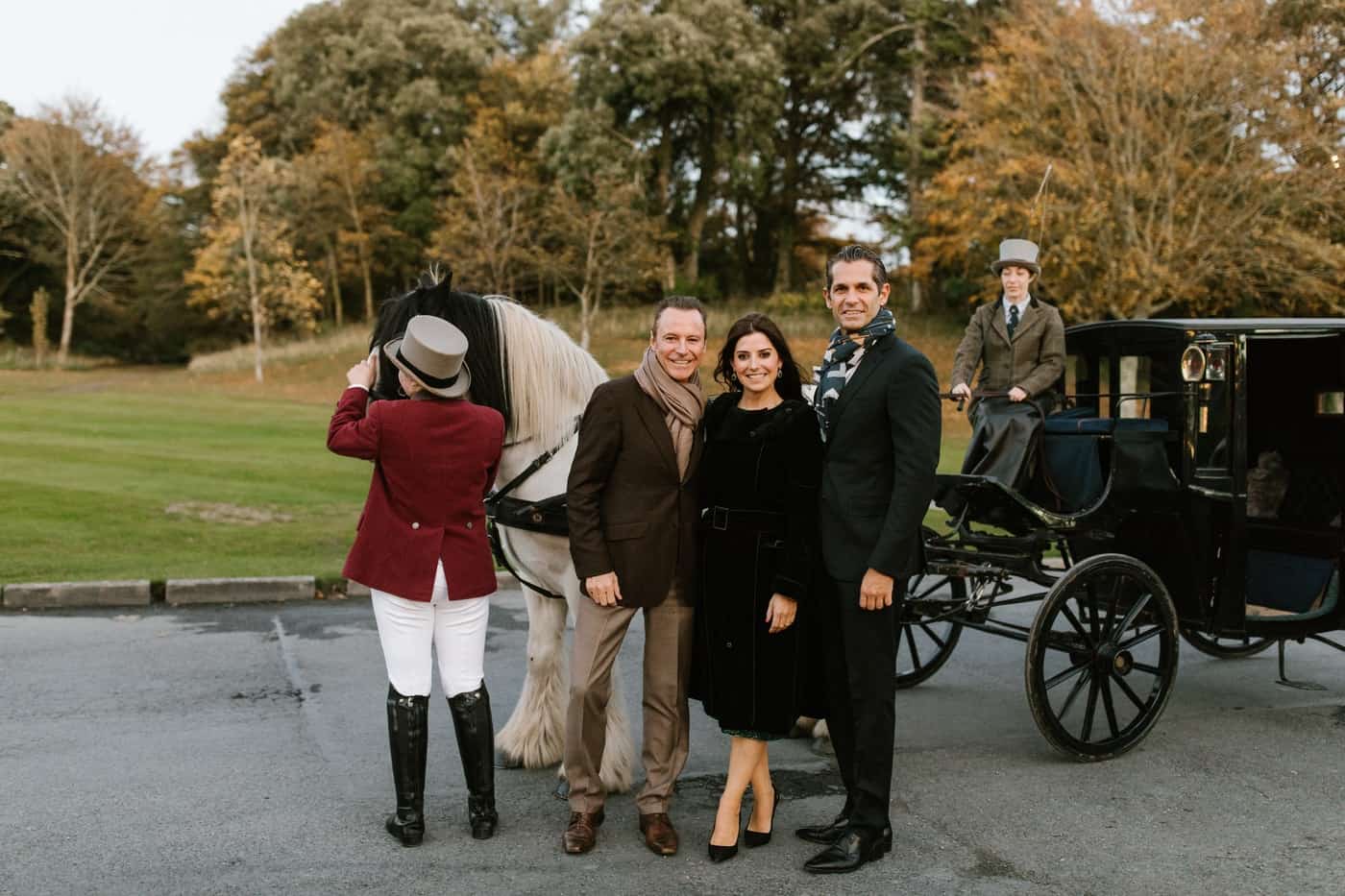 Event design Ireland at Dromoland Castle, County Clare — Olivia Buckley and guests posing beside a horse-drawn carriage at a private Irish welcome dinner.