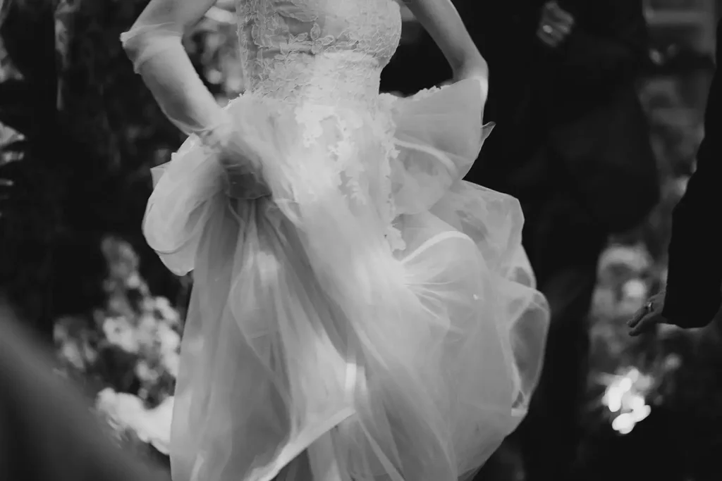 Irish destination wedding at Ashford Castle, County Mayo — bride lifting the tulle skirt of her wedding gown with both hands while dancing during the reception celebration.