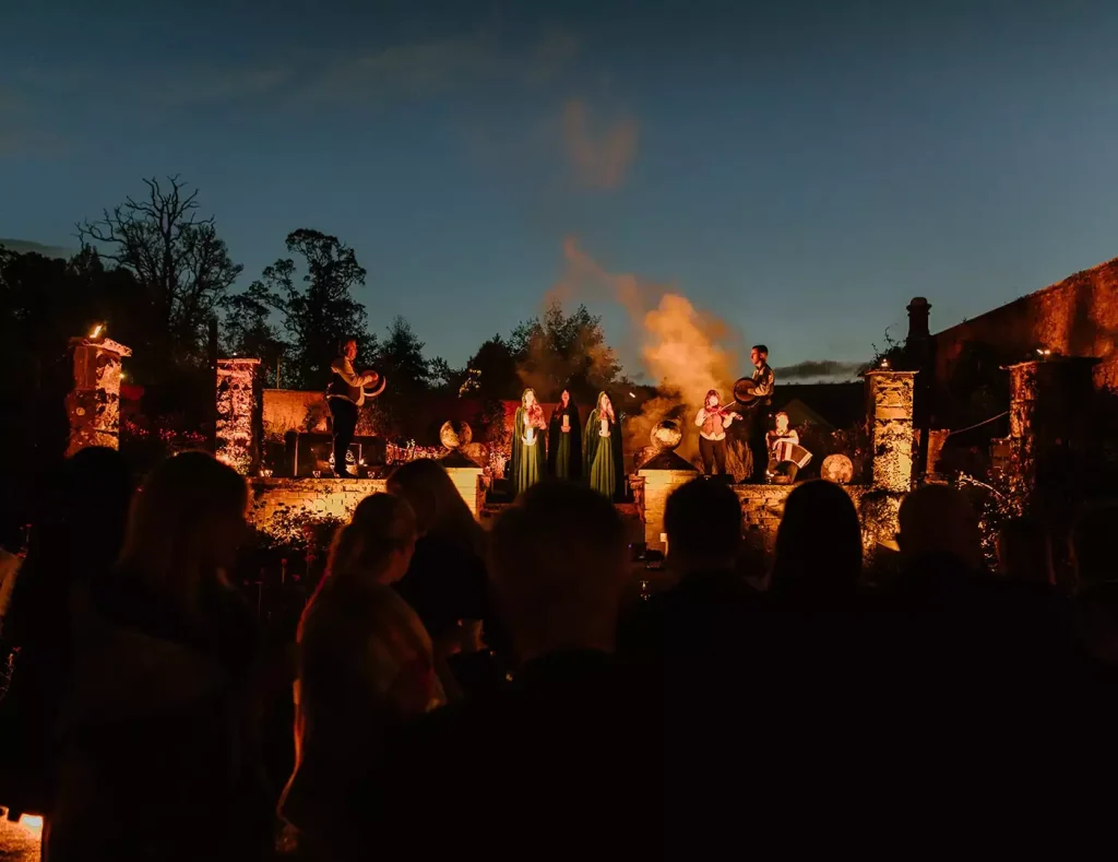 Private celebration in Ireland — Irish entertainment performers on a lit stage during an evening party, with guests watching the live performance.