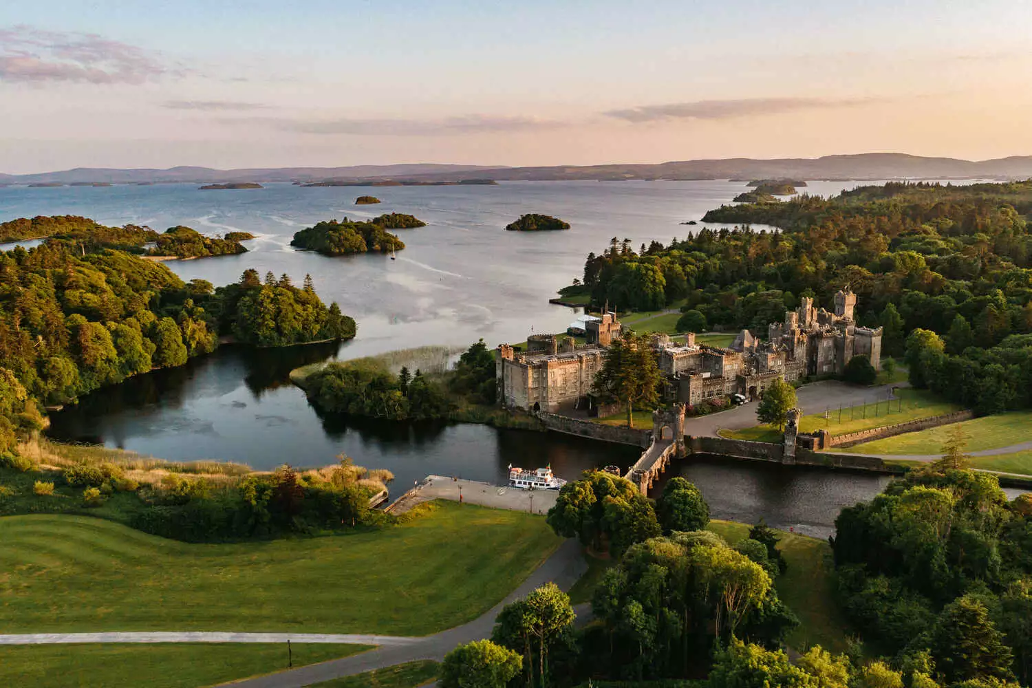 Drone shot of Ashford Castle estate at sunset.