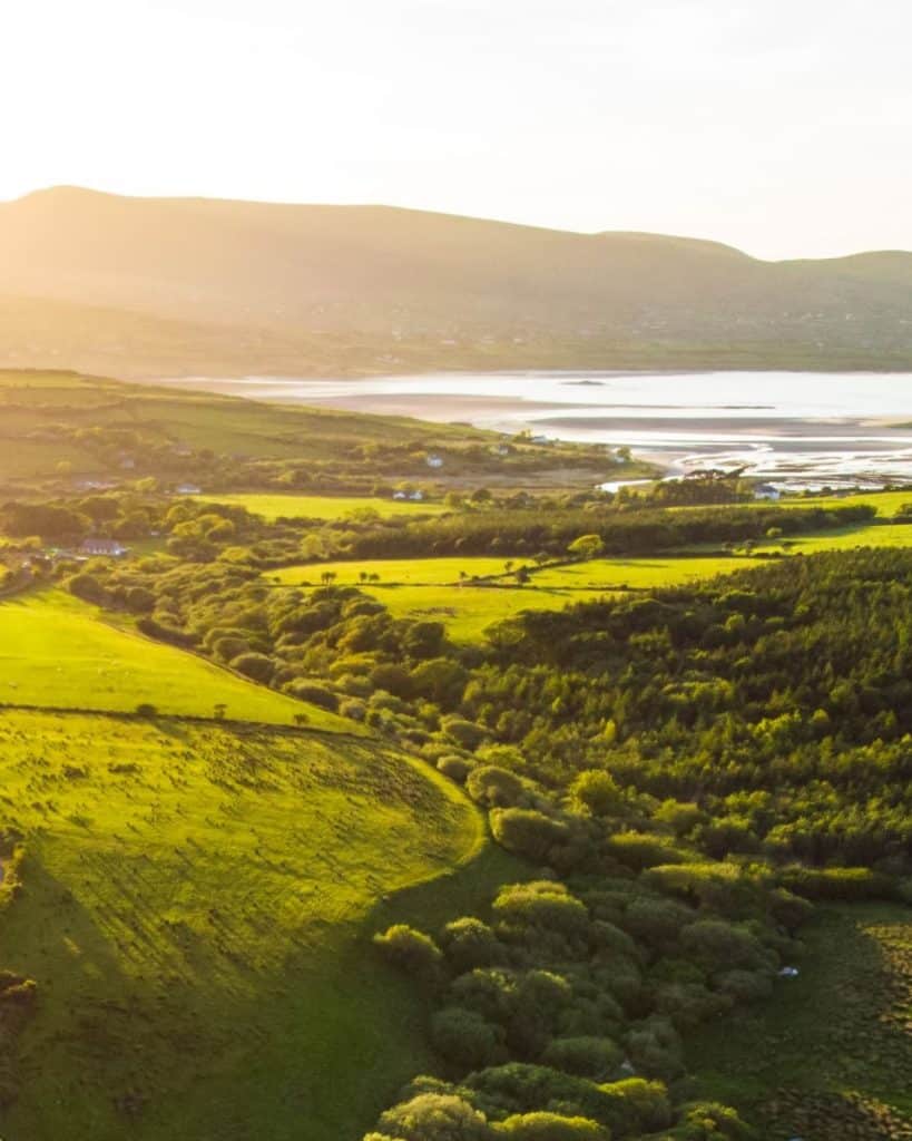 Drone shot overlooking Ireland countryside with coast view in the background.