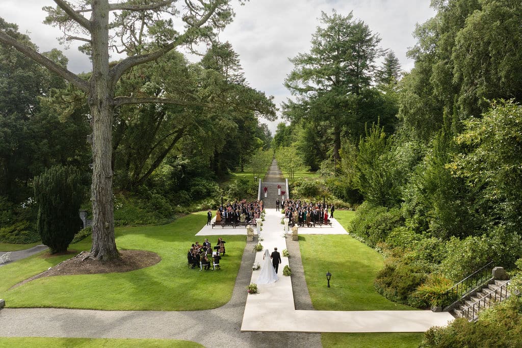 Drone angle of bride walking up aisle during ceremony in Ashford Castle, Ireland