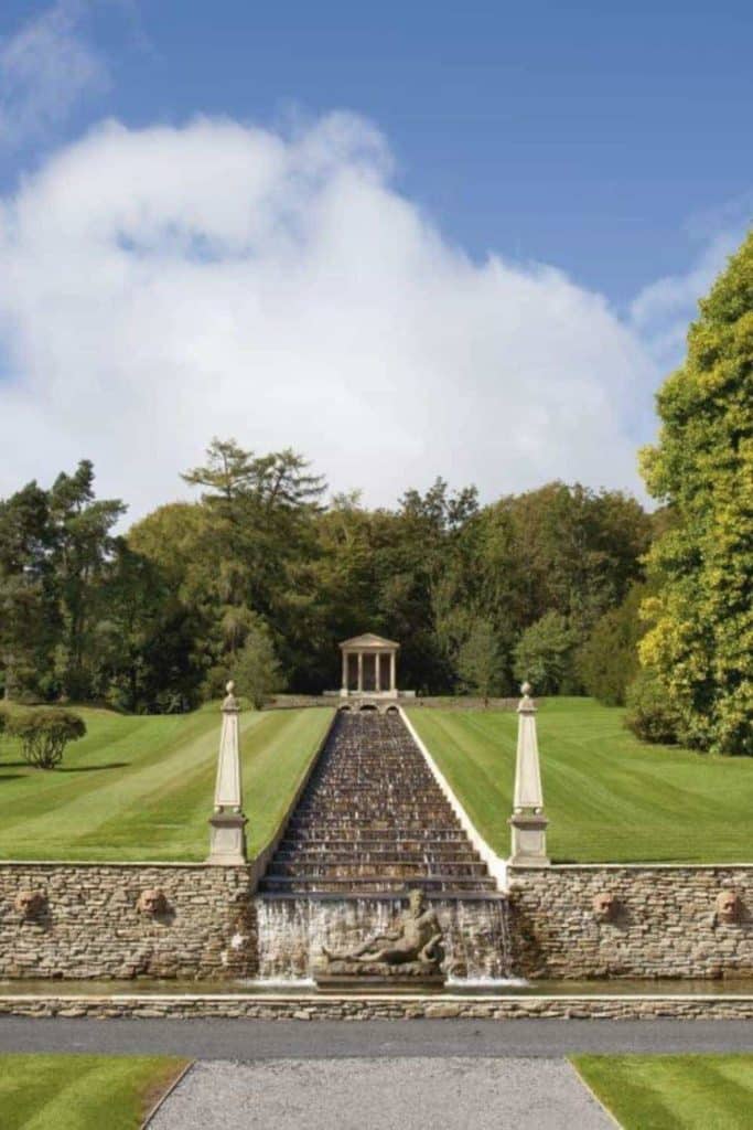 Destination wedding in Ireland Ballyfin Demesne, County Laois — formal estate grounds featuring a water cascade with classical statue detail, framed by perfectly manicured lawns and landscaped gardens within the historic demesne.