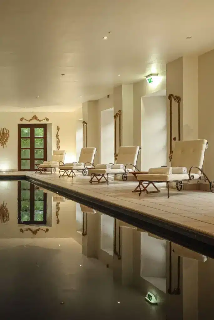 Destination wedding in Ireland Ballyfin Demesne, County Laois — spa pool with white lounge chairs and folded towels, framed by soft lighting and gold wall detailing within a refined wellness interior.