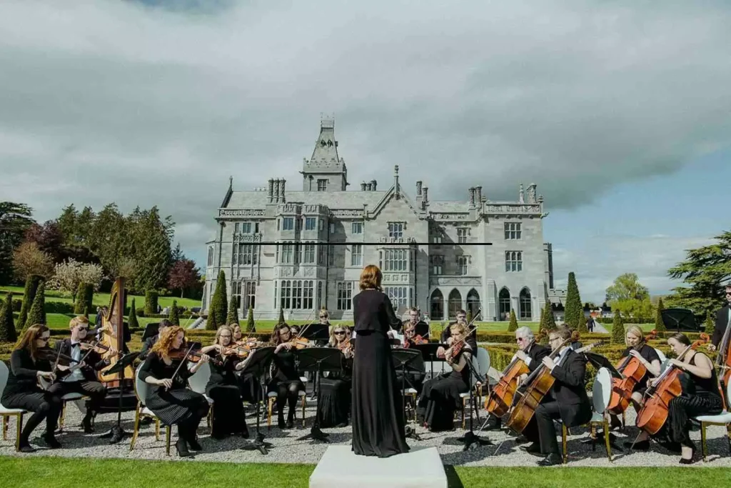 Destination wedding ceremony at Adare Manor, County Limerick — sixteen-piece orchestra performing on the estate lawn before the ceremony begins.