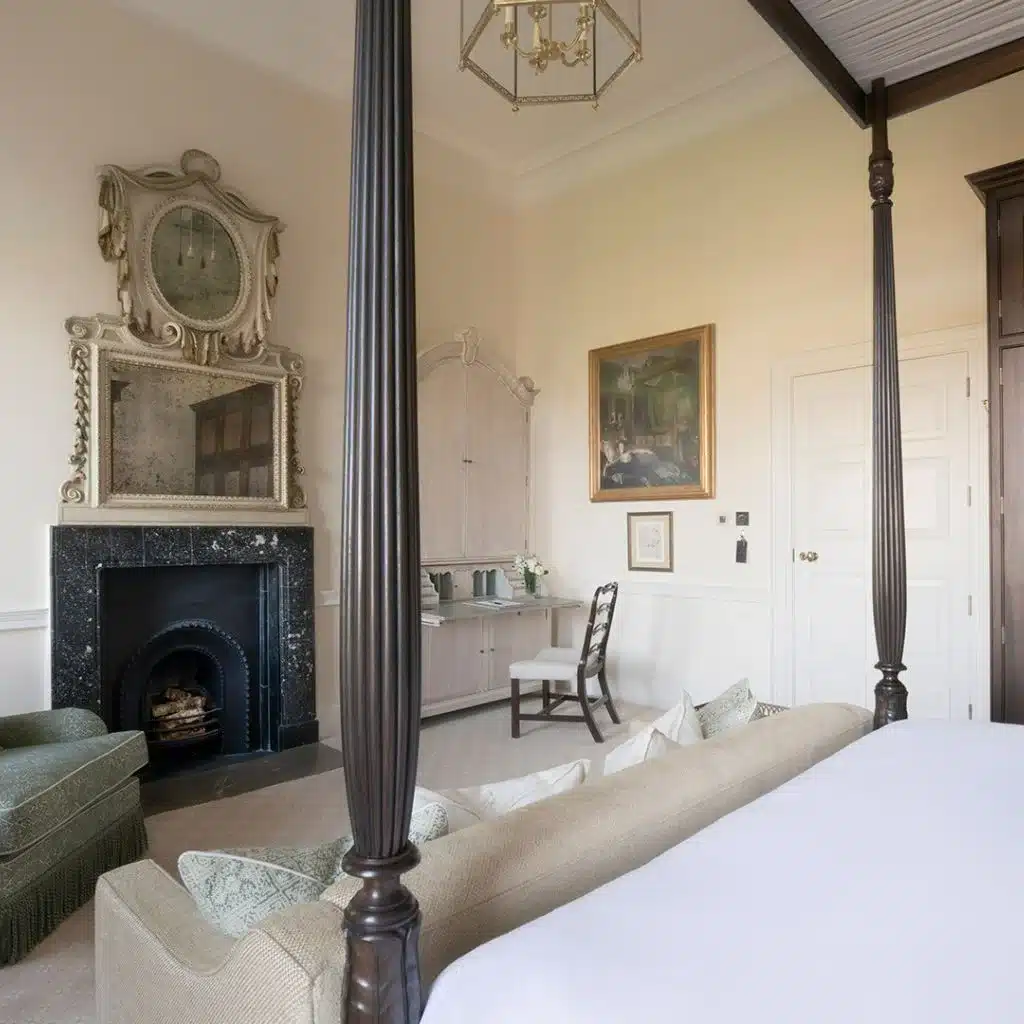 Irish destination wedding in Ireland at Cashel Palace, County Tipperary — refined bedroom suite featuring a bed with a cushioned sofa at the foot, a fireplace with mirror above, and a corner writing desk with an armchair.