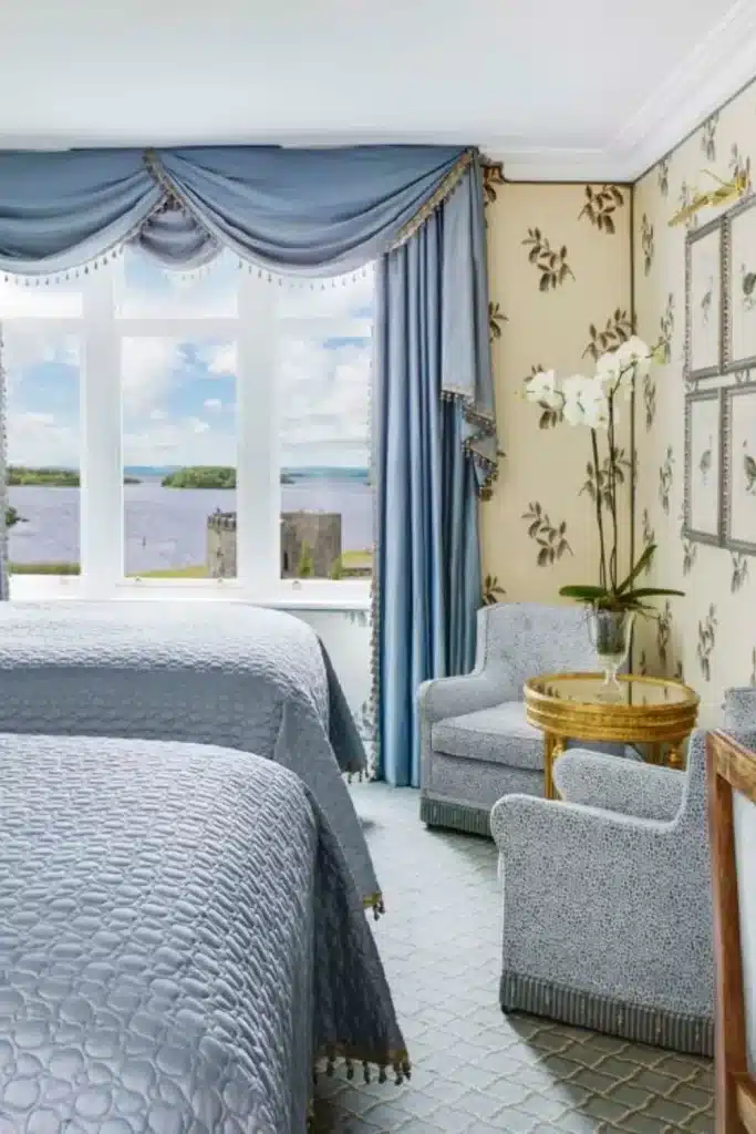 Irish castle wedding at Ashford Castle — Deluxe Queen Family Room with blue-toned interiors and views overlooking Lough Corrib through large windows.
