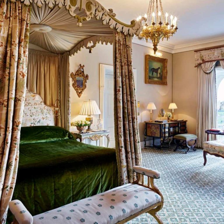 Irish castle wedding at Ashford Castle — Reagan Presidential Suite with antique four-poster bed, original fireplace, Murano chandelier, and sweeping views of Lough Corrib from the castle’s historic wing.