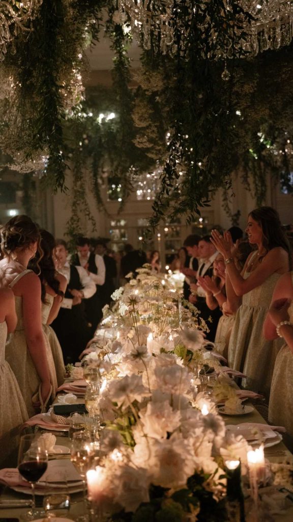 Destination wedding in Ireland at Adare Manor, County Limerick — guests gathered for a candlelit wedding dinner surrounded by white florals and ambient lighting.