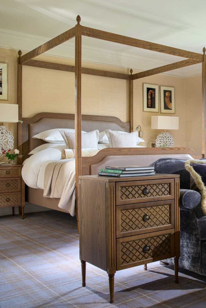 Destination wedding at Dromoland Castle, County Clare — stateroom interior with a four-poster bed, plush bedding, and a lounge area side table displaying a selection of books.