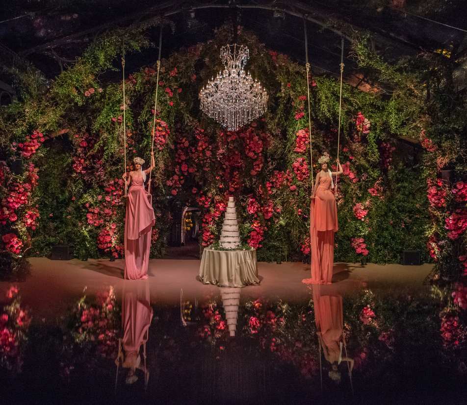Event production Ireland at Adare Manor, County Limerick — aerial performers on swings within a bespoke marquee featuring large-scale floral installations and immersive event design.