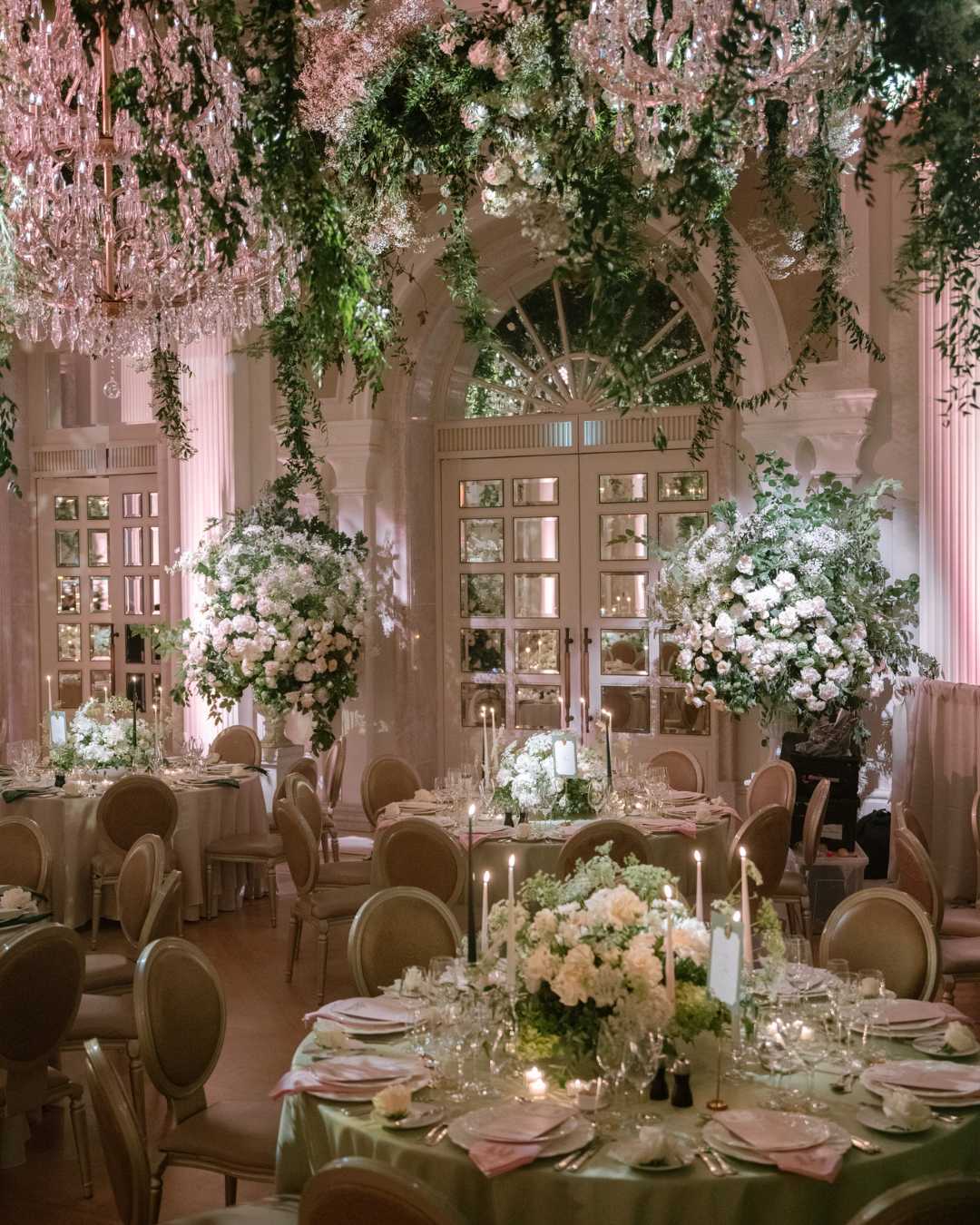 Irish destination wedding at Adare Manor, County Limerick — ballroom reception with abundant floral design and a suspended floral installation above the dining tables.