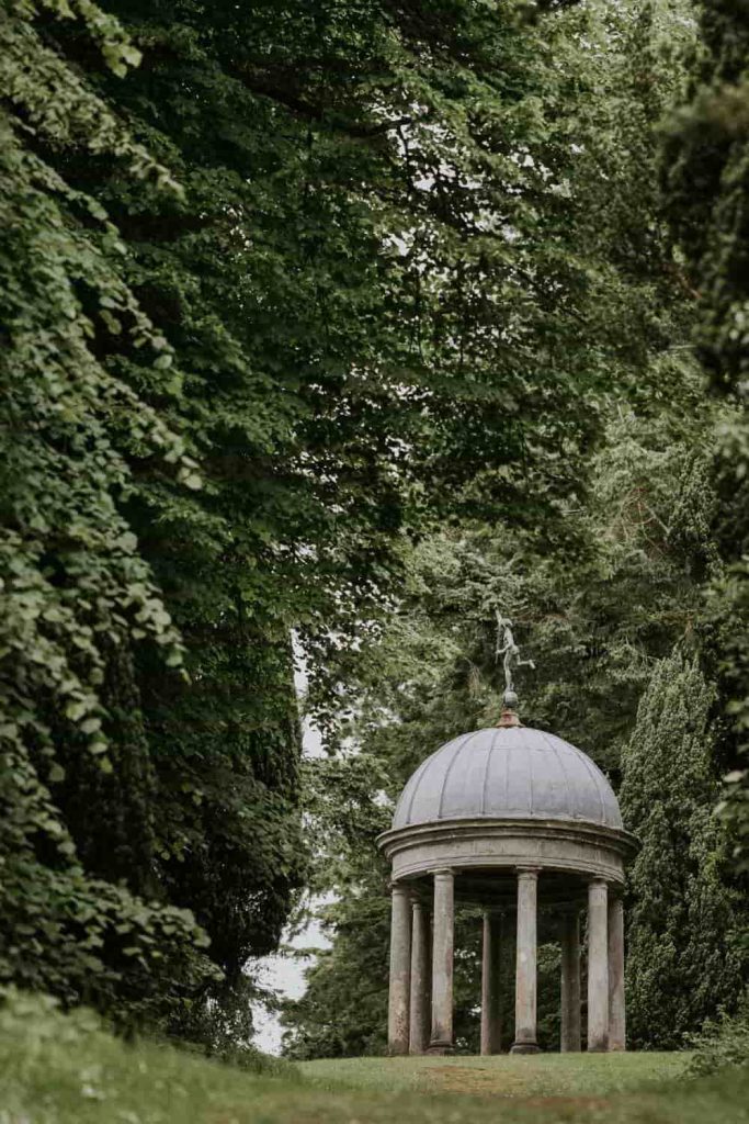 Irish destination wedding at Dromoland Castle, County Clare — The Temple of Mercury set within the estate gardens, surrounded by mature trees and landscaped greenery.