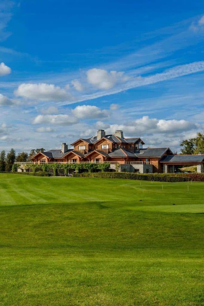 Country estate venue at Luttrellstown Castle, County Dublin — manicured golf course leading towards the clubhouse beneath a blue sky.