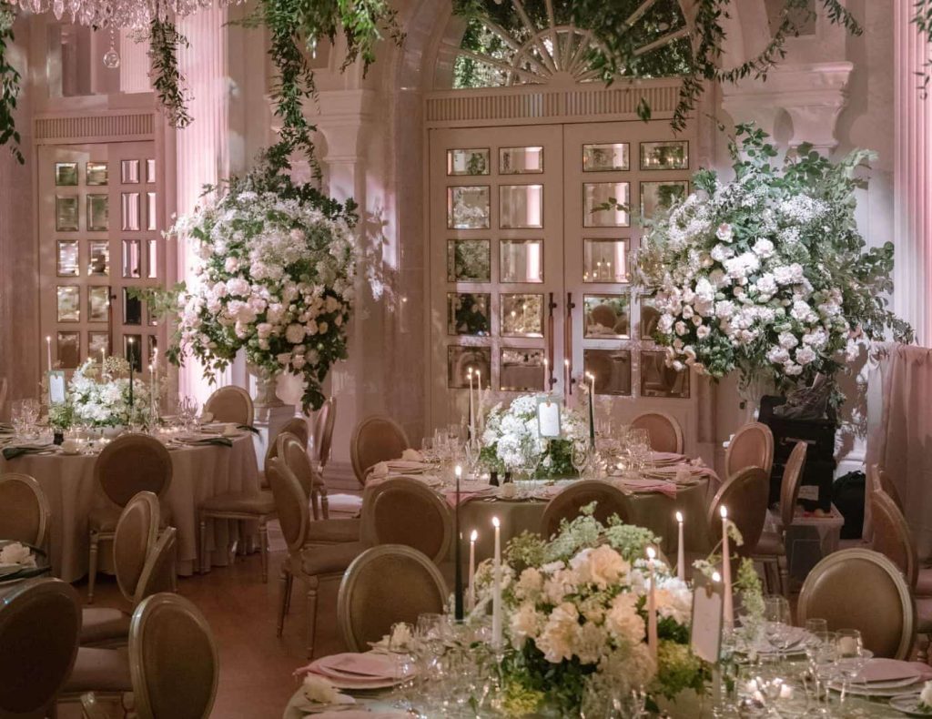 Destination wedding at Adare Manor, County Limerick — candlelit dinner setting with abundant floral installations and elevated reception design within the estate.