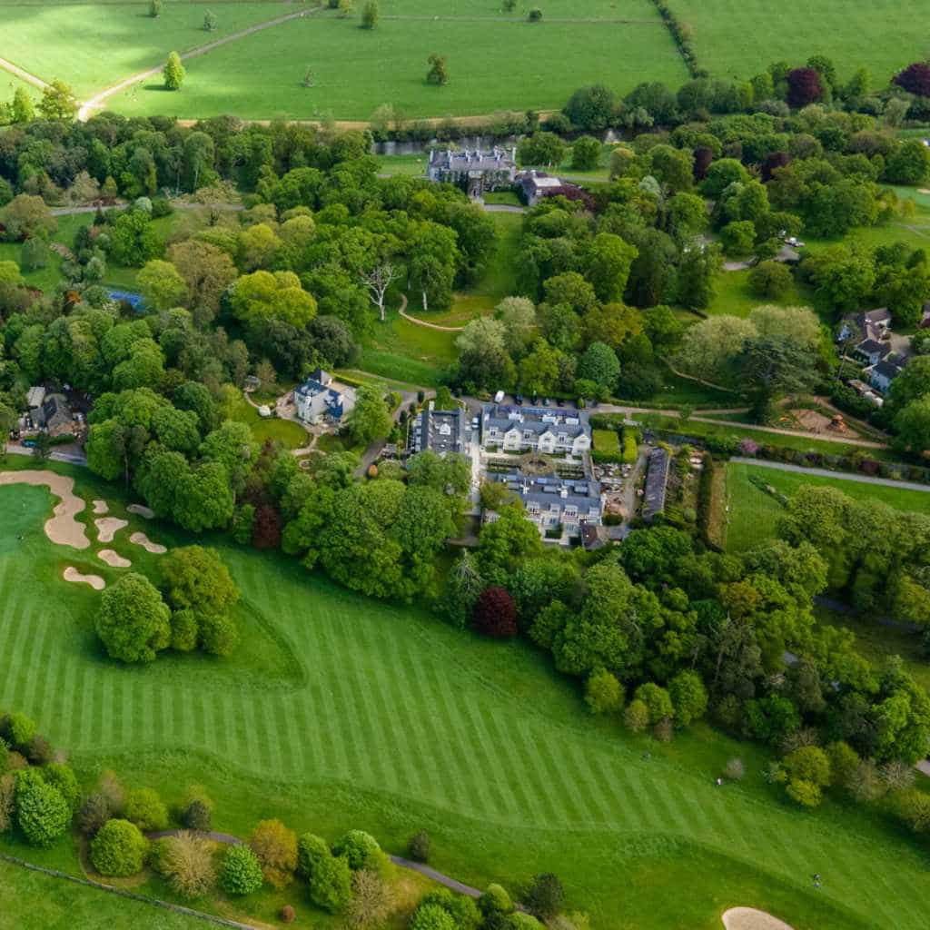 Irish destination wedding at Mount Juliet Estate, County Kilkenny, Ireland — aerial view of the property surrounded by dense woodland, mature trees, and expansive greenery across the estate grounds.