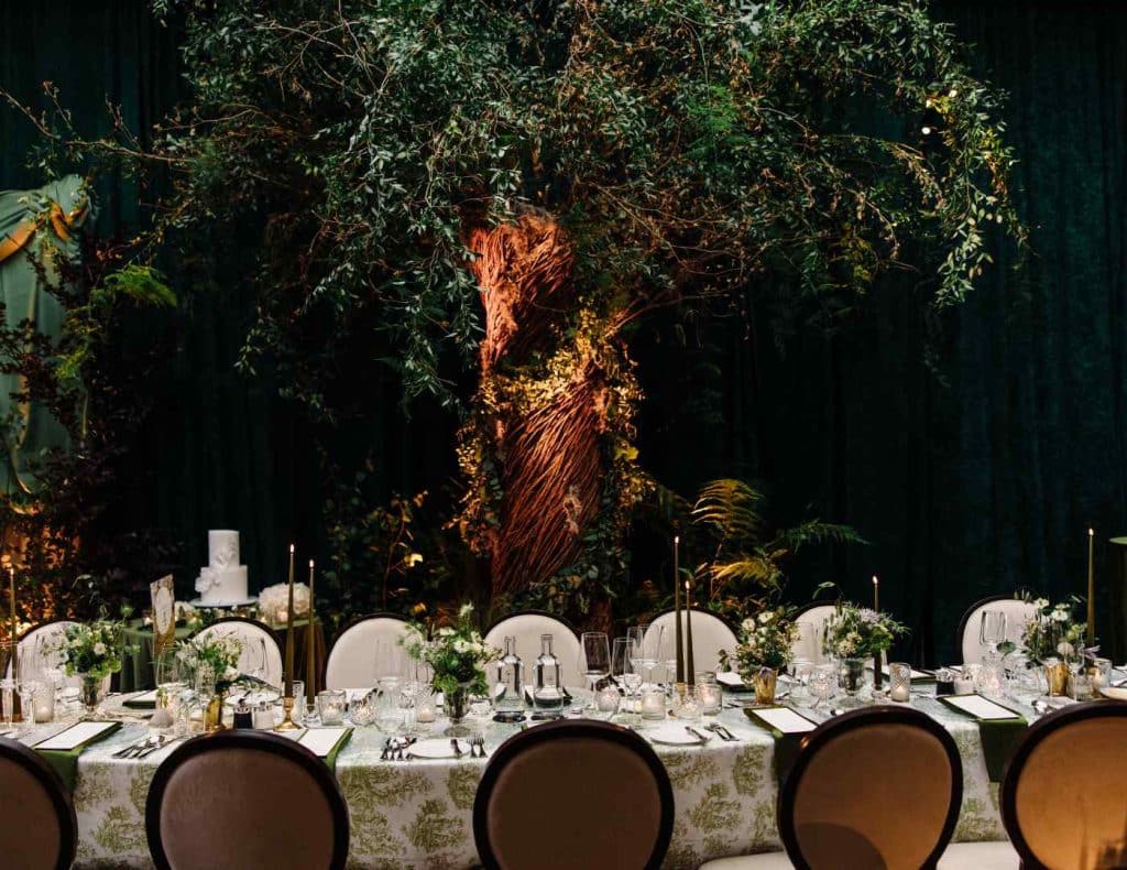 Wedding design Ireland at Cashel Palace — reception dining with a bespoke tree installation and abundant greenery tablescape.