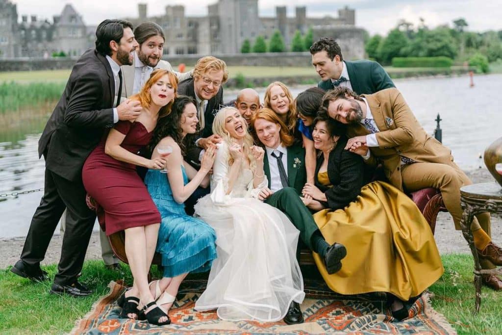 Bridal Guide feature on navigating a lopsided wedding guest list and creating comfortable experiences for guests, illustrated by family and friends gathered on the grounds of Ashford Castle.