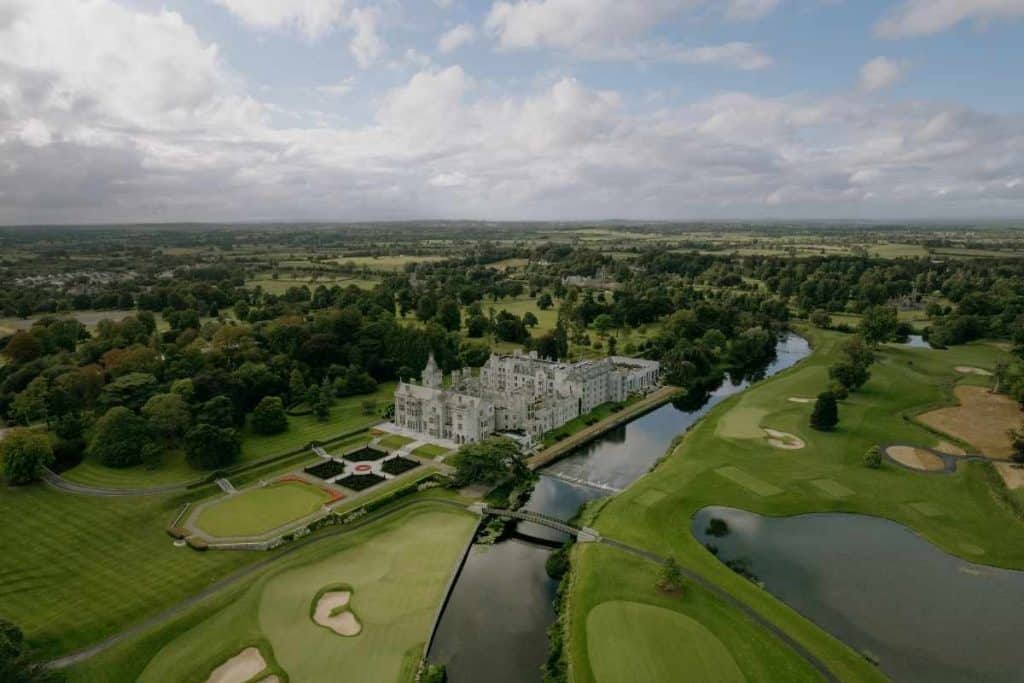 Destination I Do feature on planning guest travel and booking flights for a destination wedding, illustrated by an aerial view of Adare Manor in Ireland.