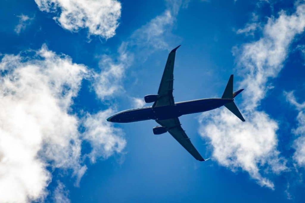 Travel + Leisure feature on Olivia Buckley's perspective on long-haul flights and international travel, illustrated by an aeroplane flying across a bright blue Irish sky.